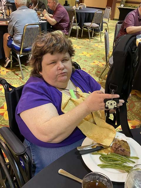 Raffle winner, Debbie, holding up a Feeldom Backpack